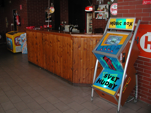 Modrý stojanový jukebox pri drevenom bare a tehlovej stene
